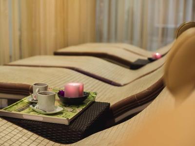 Entspannungsbereich mit Liegen, braun-beiger Polsterung und Serviertablett mit Kerze und Tasse.