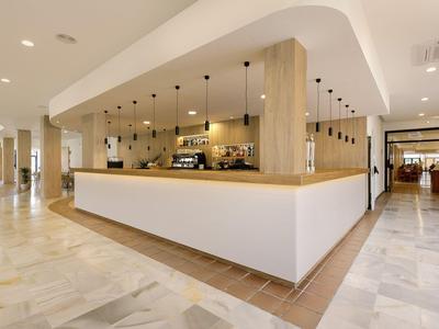 Moderner Hotellobby-Empfangsbereich mit hellem Holz und weißen Wänden.