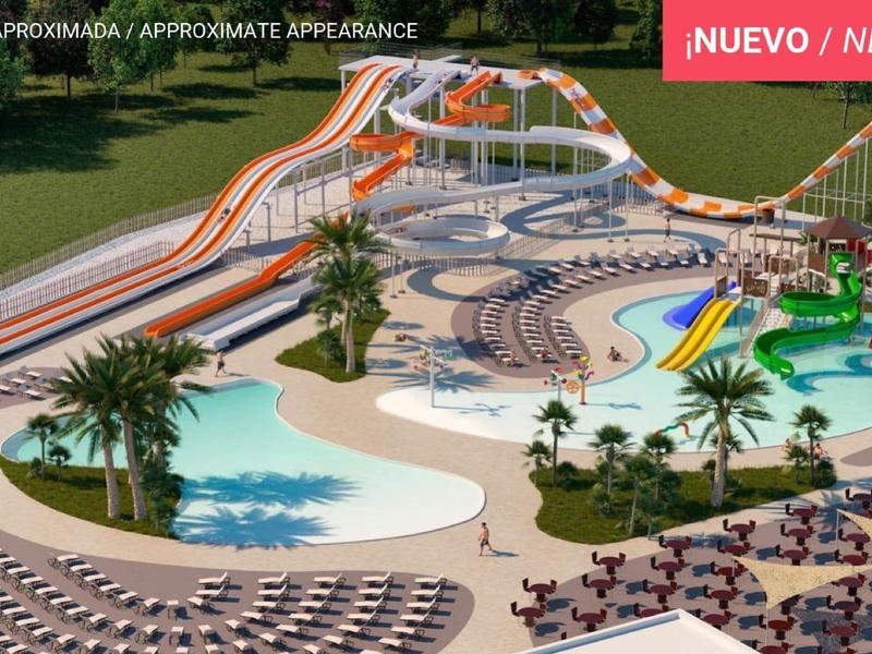 Großer Wasserpark mit Pools, Wasserrutschen, Palmen und Liegestühlen, umgeben von grüner Landschaft.