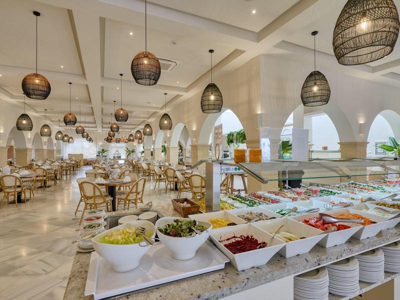 Buffet di ristorante d'hotel luminoso con piatti vari e decorazioni eleganti.