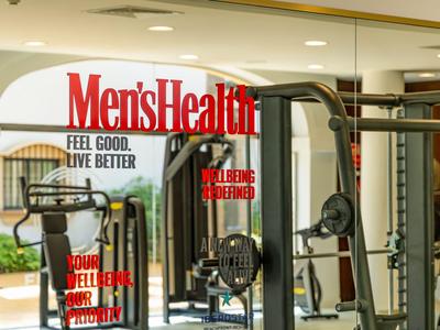 Moderne Fitnessgeräte in einem Hotel-Fitnessraum mit Spiegelwänden.