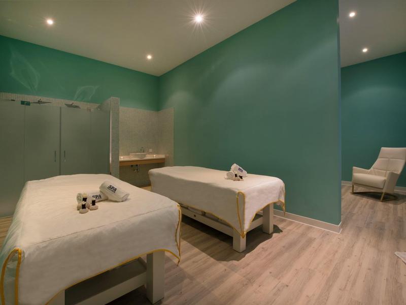 Modern wellnessruimte met twee massagetafels en zachte verlichting