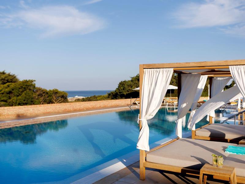Luxe zwembad met open gordijnen en uitzicht op de zee