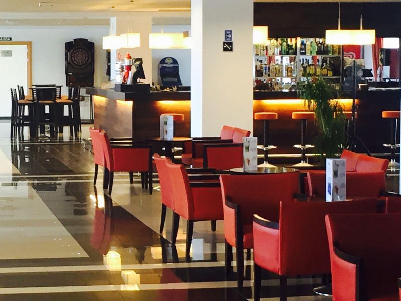 Ristorante d'hotel moderno con sedie rosse e atmosfera elegante.