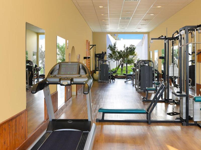 Moderne fitnessapparatuur in een lichte, ruime hotelgymzaal.