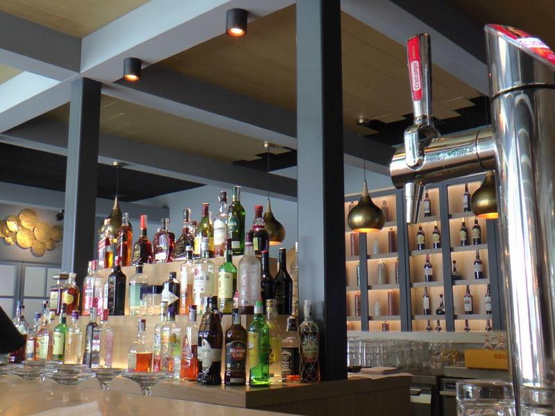 Bar met diverse drankflessen en biertaps in een stijlvolle hotel lounge.