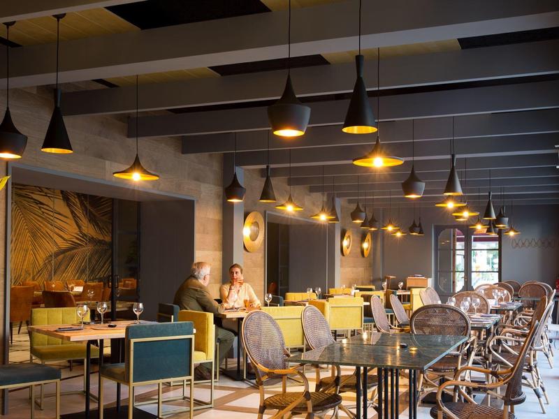 Gezellig hotelrestaurant met warme verlichting en een mix van moderne en rustieke meubels.