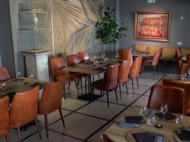 Gezellige eetkamer met bruine leren stoelen en houten tafels klaar voor een maaltijd in een moderne stijl.