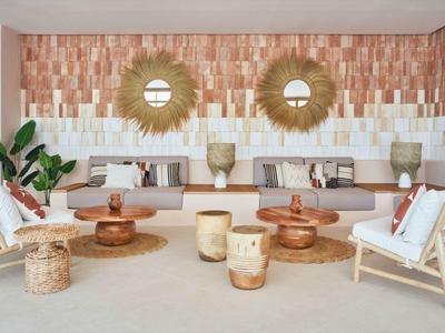 Světý obývací pokoj s pohodlným posezením, dřevěnými stolky a dekorativními stěnovými prvky v rekreačním domě.