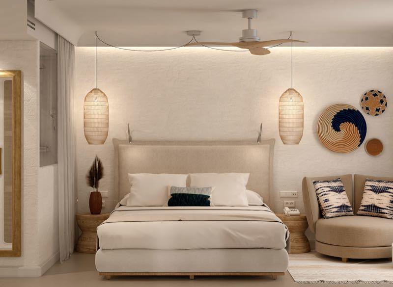 Moderní hotelový pokoj s velkou postelí, křeslem a balkonem s výhledem na moře.