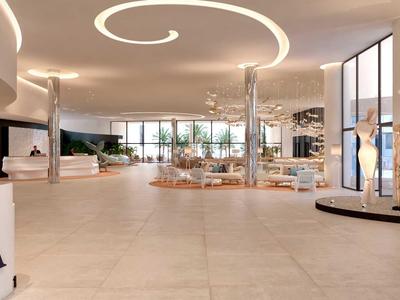 Ampia e luminosa hall dell'hotel con aree salotto, sculture moderne e grandi finestre.