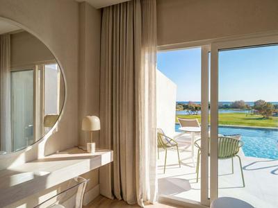 Heller Hotelbalkon mit Poolblick, zwei Stühlen und sanfter natürlicher Beleuchtung.