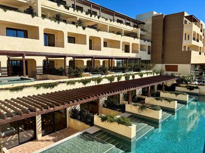 Modernes Hotel mit diversen Balkonen und einem Pool mit Sonnenterrassen.