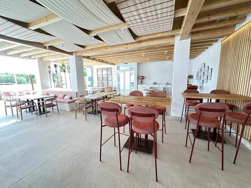 Helles Restaurant mit Holzmöbeln, bequemen Sitzgelegenheiten und modernen Dekorelementen.