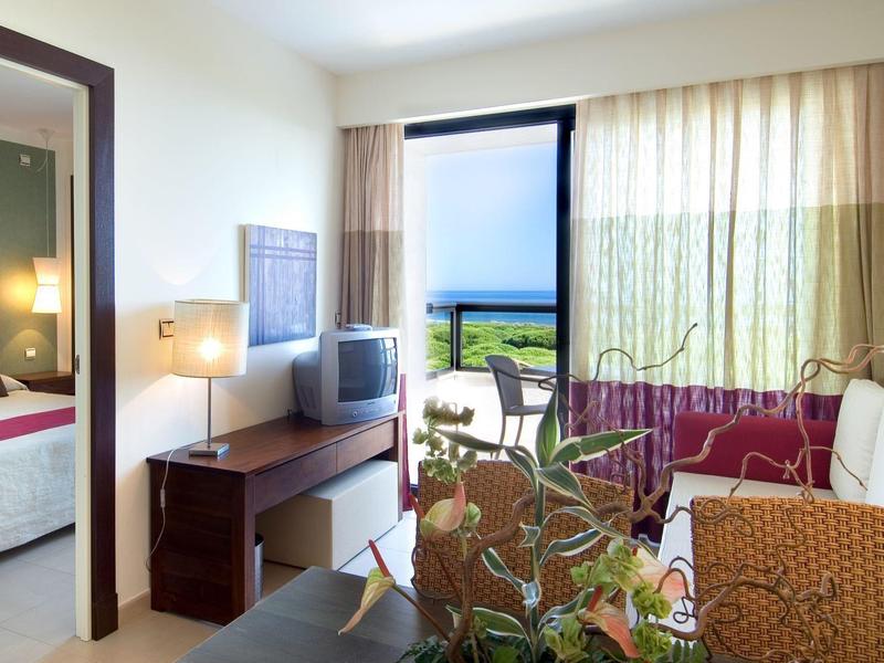 Moderní hotelový pokoj s výhledem na moře a balkonem.