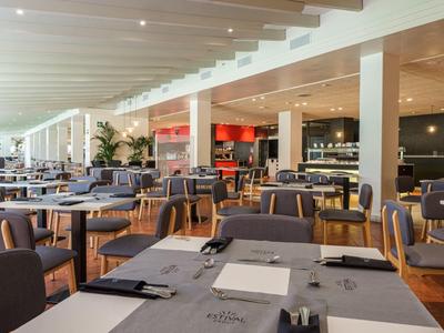 Restaurante moderno y luminoso con mesas preparadas y sillas cómodas en un hotel.