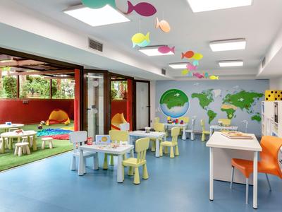 Sala giochi luminosa per bambini con mobili colorati e decorazioni murali.