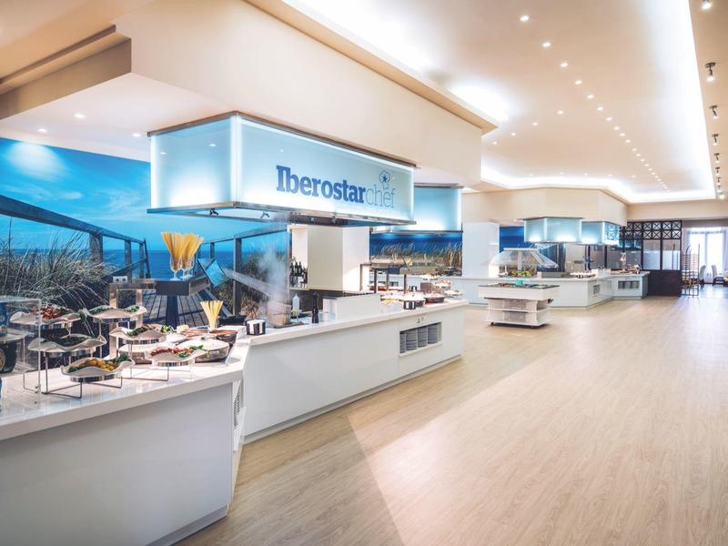 Restaurante buffet moderno y luminoso con grandes ventanales y varias estaciones de comida.