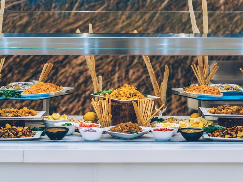 Buffet con variedad de platos en un restaurante de hotel, presentado de manera apetecible en platos.