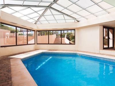 Piscine intérieure couverte avec eau bleue et grandes fenêtres