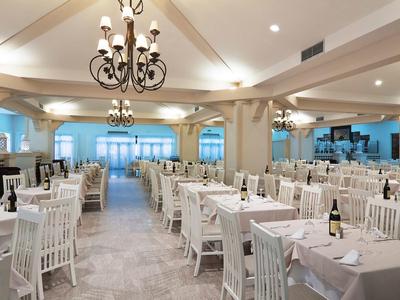 Salle de banquet spacieuse avec tables élégamment dressées et lustres classiques.