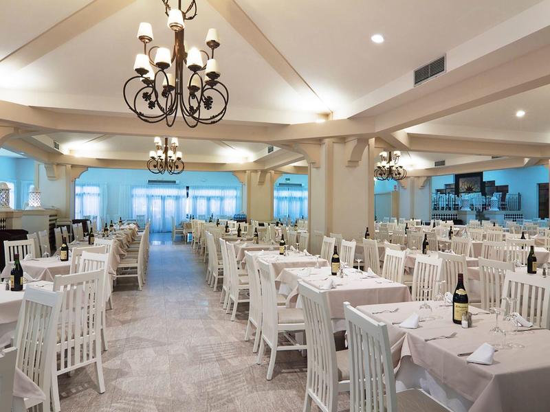 Salle de banquet spacieuse avec tables élégamment dressées et lustres classiques.