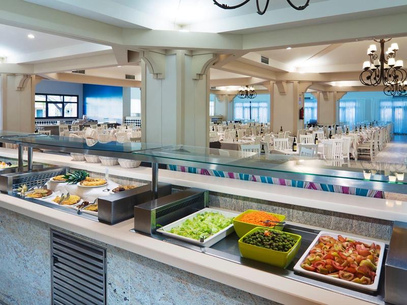 Espace buffet avec salades et légumes dans une salle à manger lumineuse et moderne.