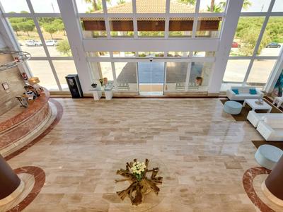 Spacious, bright hotel lobby with seating areas and large windows overlooking outdoor scenery.