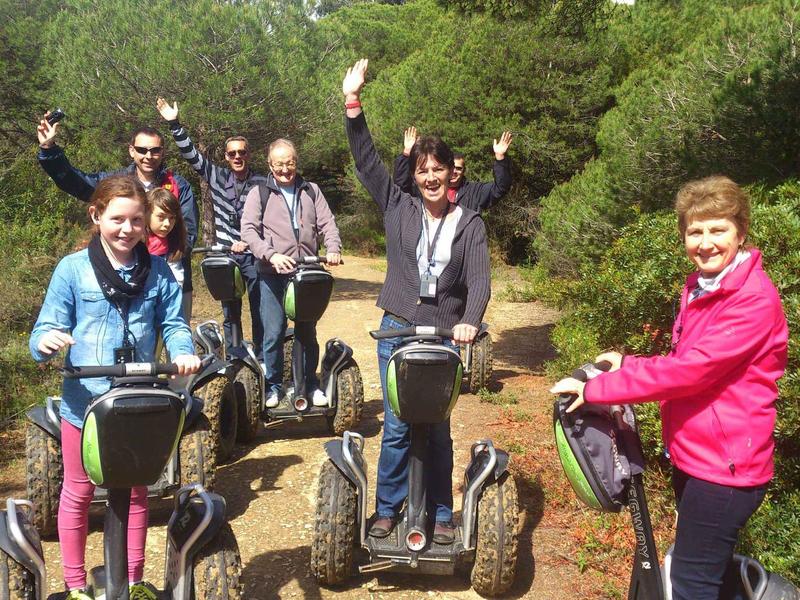 Gruppo di sei persone su Segway in una zona boschiva, che posano felici.