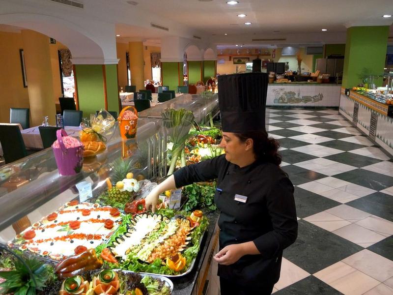 Buffet mit vielfältigen Gerichten, farbig angerichtet, in einem großen, hellen Speisesaal.