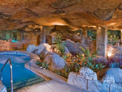 Un accogliente spa rocciosa con vasca idromassaggio e illuminazione rilassante.