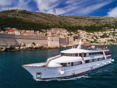 Battesimo bianco su acque blu vicino a una città costiera storica con colline.
