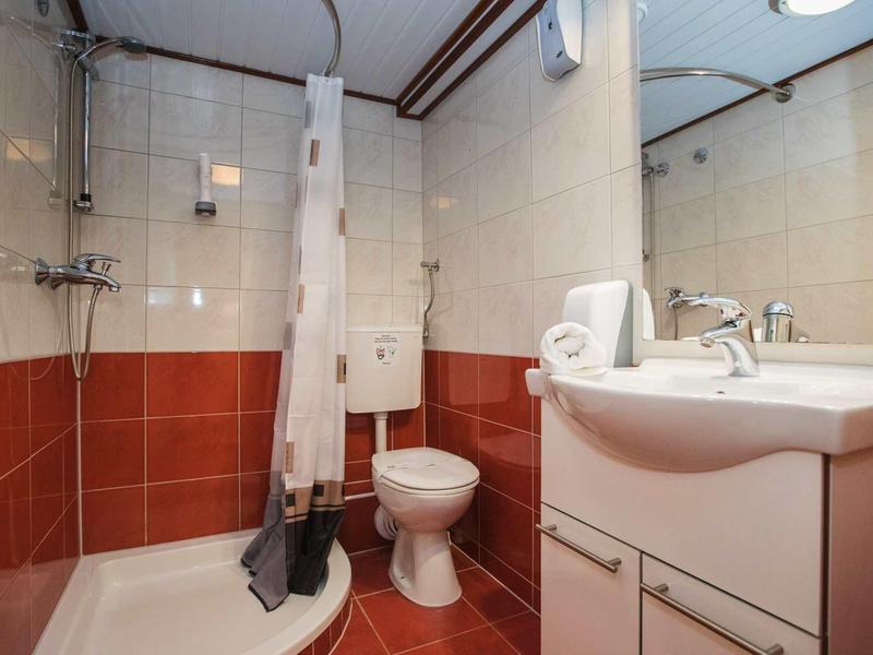 Bagno piccolo con doccia, WC e lavabo con specchio in una camera d'albergo.