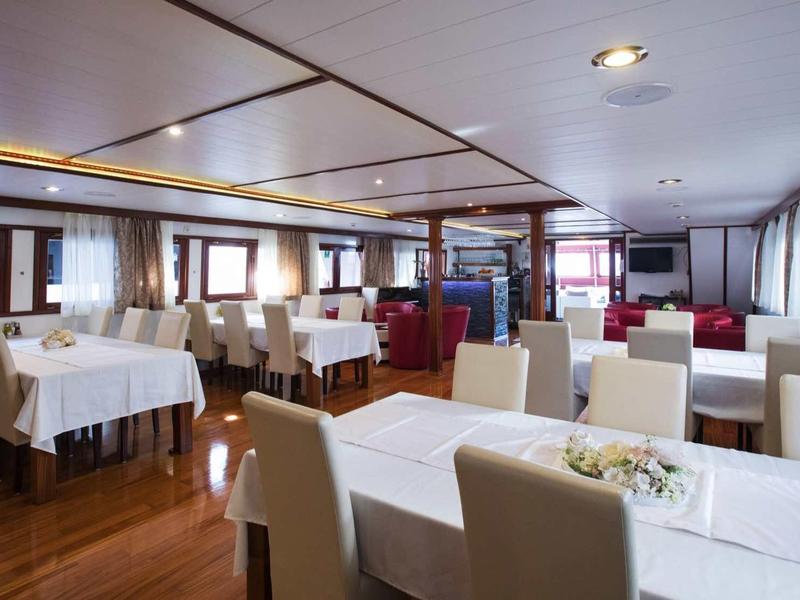 Ristorante elegante con tavoli coperti di bianco e comode sedute in un ambiente luminoso.