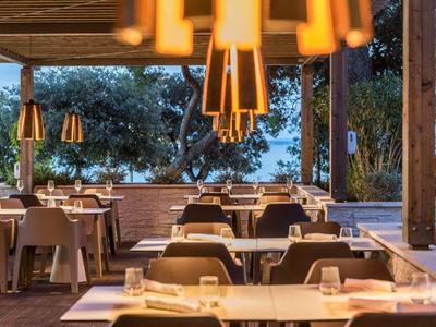 Modernes Außenrestaurant mit gedeckten Tischen und warmem Licht bei Dämmerung