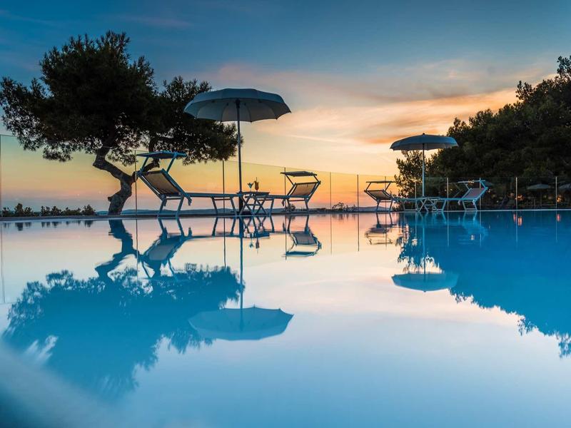 Littoral avec hôtels, forêts et plages sur une mer bleue calme sous un ciel clair.