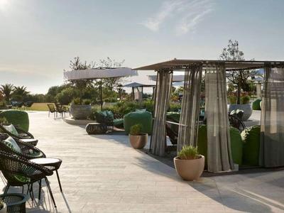 Terrasse sur le toit avec sièges, plantes et protections solaires en plein jour.