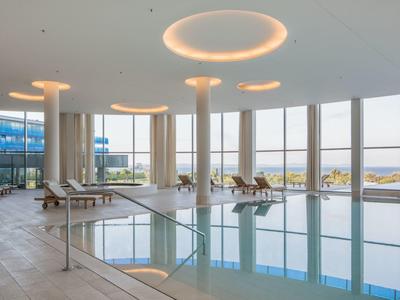 Nowoczesny basen kryty z dużymi oknami i widokiem na morze w hotelu