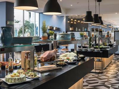 Buffet élégant avec divers plats dans une salle à manger moderne avec de grandes fenêtres.
