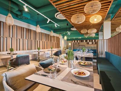 Modern restaurant with wooden accents, cozy seating, and stylishly set tables.