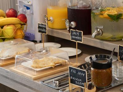 Buffet with fresh fruit, juices, and jams at a hotel.