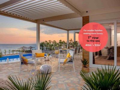 Terrasse mit modernen Stühlen und Blick auf den Pool und das Meer bei Sonnenuntergang.