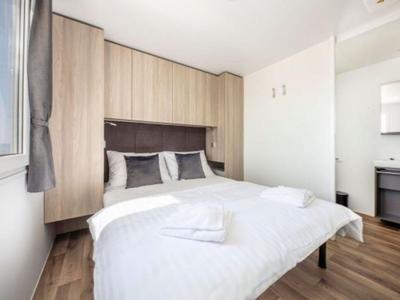Helles Hotelzimmer mit Doppelbett, Holzboden und modernen Möbeln.