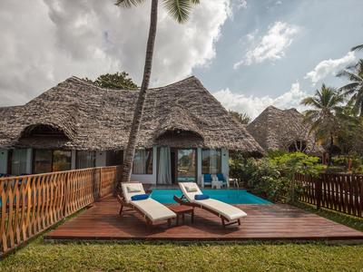 Bungalow mit Strohdach, Terrasse mit Liegestühlen und kleinem Pool in tropischer Umgebung