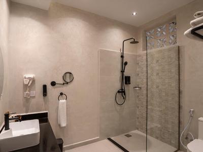 Modernes Badezimmer mit begehbarer Dusche, Waschbecken und Toilette in neutralen Farben.