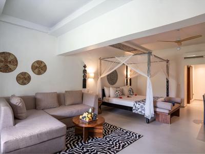 Ein modernes Wohnzimmer mit beiger Schlafcouch, rundem Holztisch und dekorativen Wänden in einem hellen Raum.