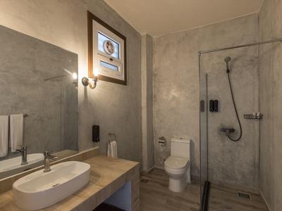 Modernes Badezimmer mit Waschbecken, Toilette und begehbarer Glasdusche in neutralen Farben.