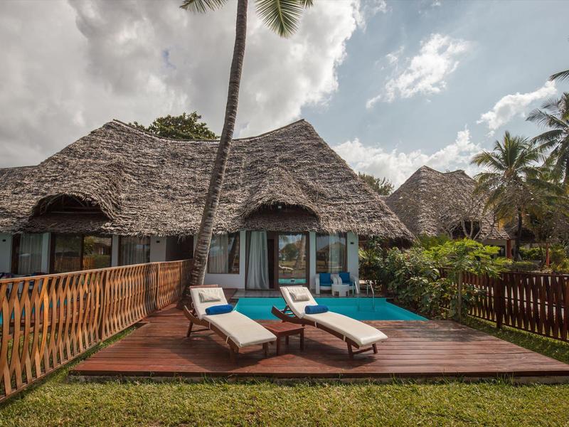 Bungalow mit Strohdach, Terrasse mit Liegestühlen und kleinem Pool in tropischer Umgebung