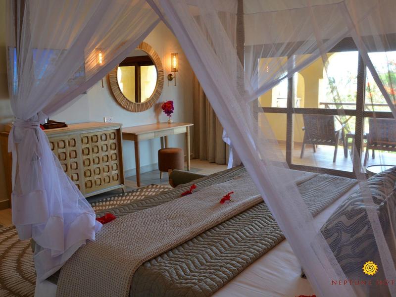 Gemütliches Hotelzimmer mit Himmelbett und Blick auf eine Terrasse