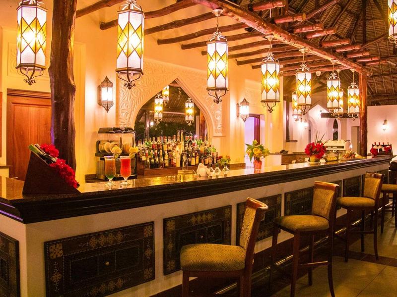 Gemütliche Bar mit warmen Lichtern, Holzdecke und bequemen Barhockern in einladendem Ambiente.